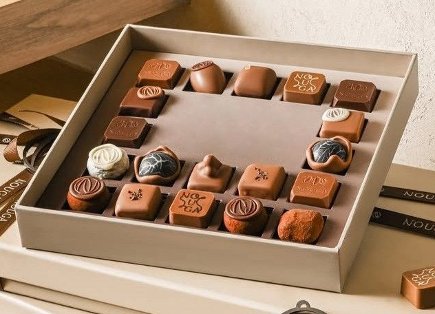 Concept image of a luxury chocolate tray insert with individual compartments, designed to protect chocolates and keep presentation clean inside premium gift packaging—Shabouk solutions in the UAE.