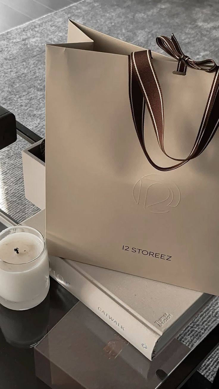 Concept image of a luxury paper bag with woven ribbon handles and a debossed logo, representing premium retail and gifting packaging solutions by Shabouk in the UAE.
